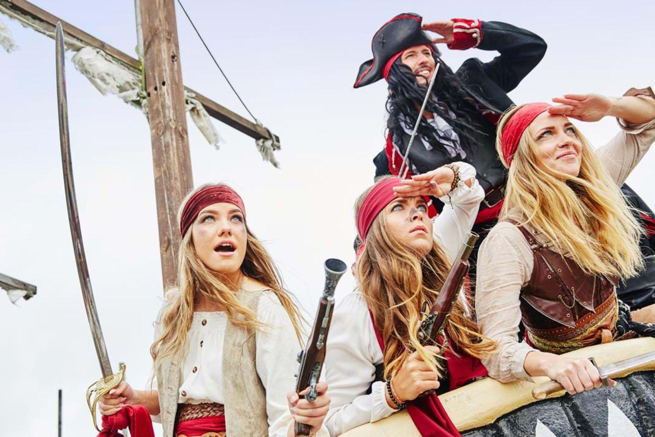 a group of people dressed as pirates are sitting on top of a pirate ship .